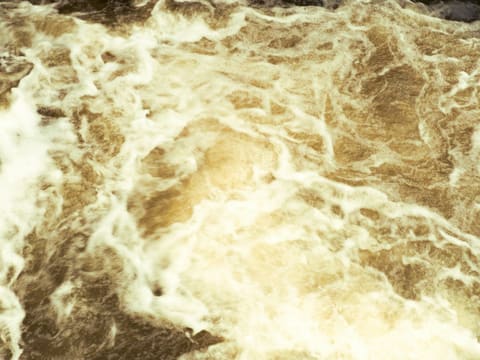 Backlit Stone & Onyx Panels: turbulent brown water with white foam swirls