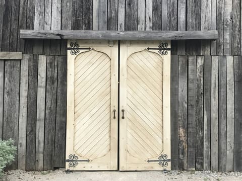 Sliding Barn & Pocket Door Systems: a couple of wooden doors sitting next to a building