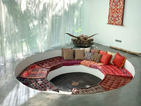 Cushions & Throws: a circular couch with a lot of pillows on top of it