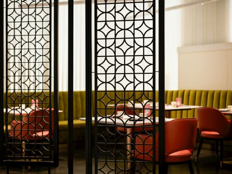 Decorative Metal Screens & Partitions: a room divider in a restaurant with red chairs
