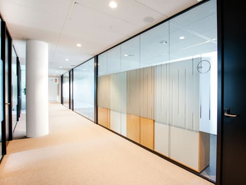 a hallway with glass walls and a clock on the wall