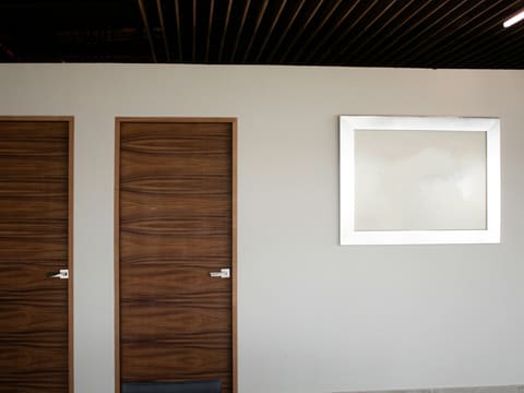 brown wooden door beside white wall