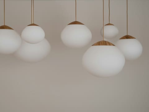 Modern white spherical pendant lights with wooden accents