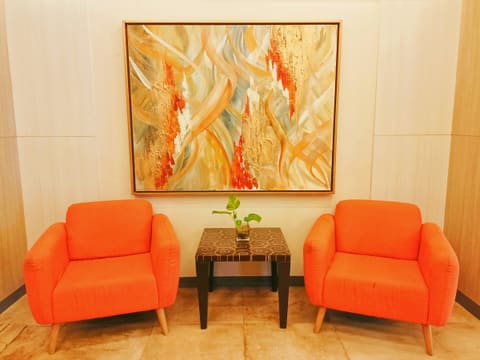 Lobby & Lounge Furniture: two orange chairs face a painting