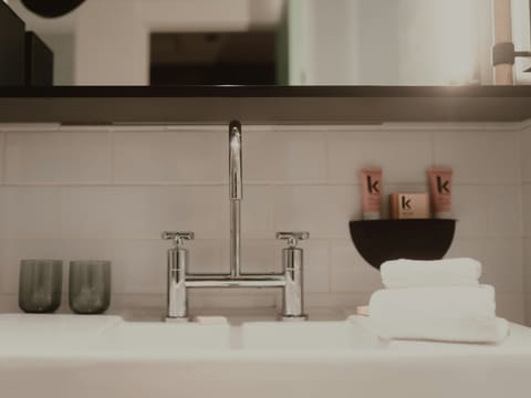 Mixers & Taps: a modern bathroom sink with chrome faucet, glasses, and towels