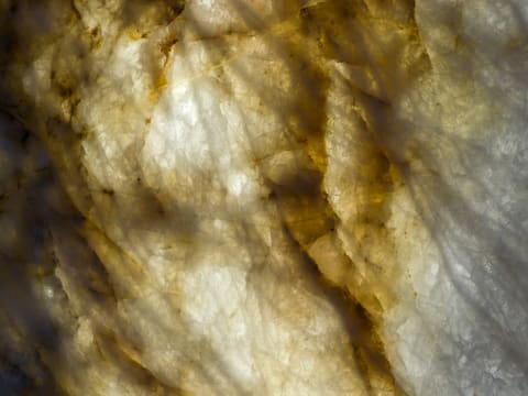 Onyx (Backlit): backlit translucent stone slab with golden veins and crystalline texture