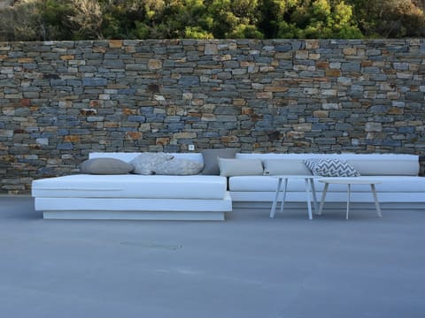Outdoor Furniture: a white couch sitting next to a stone wall