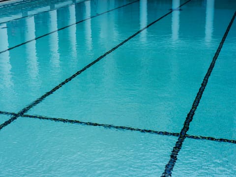 A swimming pool with a tiled floor and blue water