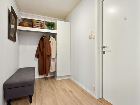 Shoe Cabinets & Entry Storage: a walk in closet with a bench and coat rack