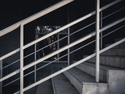 gray concrete staircase with stainless steel railings