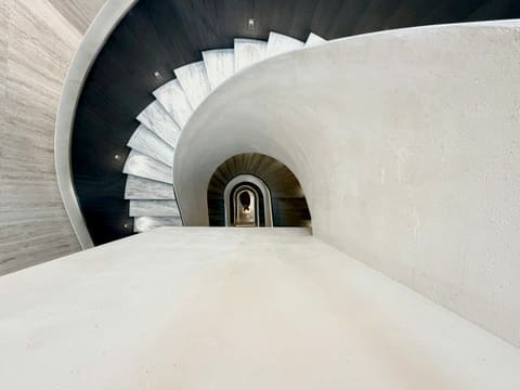 Stone Staircases: looking down a modern concrete spiral staircase with dark accents