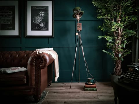Table & Floor Lamps: a living room with a brown couch and a green wall