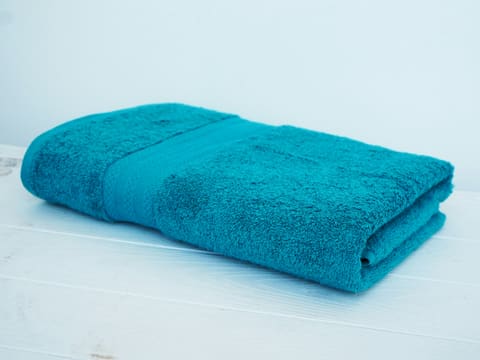 Towels & Bathrobes: a blue towel sitting on top of a white table