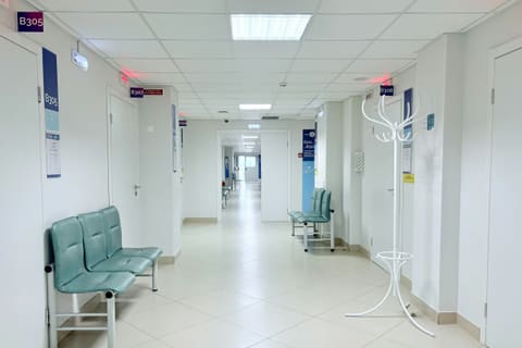 Empty hospital corridor with benches and doors
